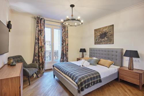 une chambre avec un lit, une chaise et une fenêtre dans l'établissement Apartment Le Marais by Studio prestige, à Paris