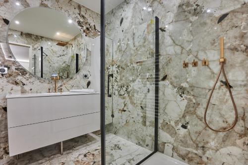 une salle de bain avec un lavabo blanc et une douche dans l'établissement Apartment Le Marais by Studio prestige, à Paris