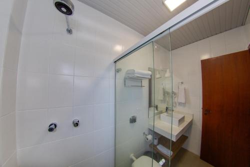 a bathroom with a shower and a toilet and a sink at Flipper Hotel in Laguna