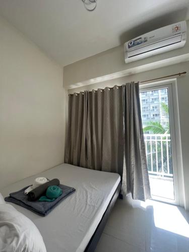 ein kleines Schlafzimmer mit einem Bett und einem Fenster in der Unterkunft 4Brother's Staycation by Jessika in Manila