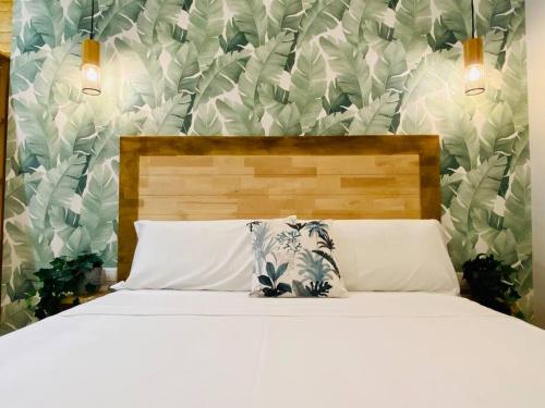 um quarto com uma cama branca e papel de parede floral em Cabanyal Room 5 - New & Stylish by the Beach em Valência