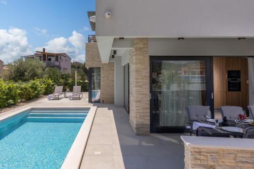 a villa with a swimming pool and a house at Villa Nadja ZadarVillas in Bibinje