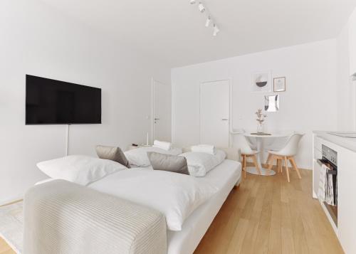 a white living room with a white couch at Stylish & Modern Apartment - Private Garden & Free Parking in Vienna