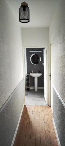 La salle de bains est pourvue d'un lavabo et d'un lavabo blanc. dans l'établissement Marianne Cottage Chambre d'Hotes, à Couvains