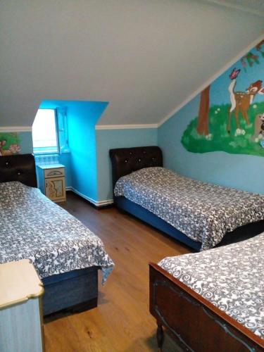 a bedroom with two beds and a painting on the wall at Taqnvac hrashq in Dilijan