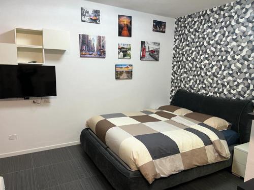Schlafzimmer mit einem Bett und einem Flachbild-TV in der Unterkunft Apartment Tazzoli 11 in Carugo