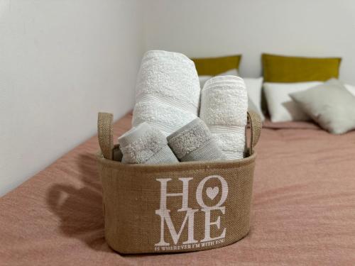 a basket of toilet rolls and towels on a bed at Moderna habitación en el corazón de Alicante in Alicante