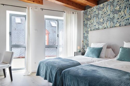 two beds in a bedroom with blue and white walls at Val Arties 3 by FeelFree Rentals in Arties