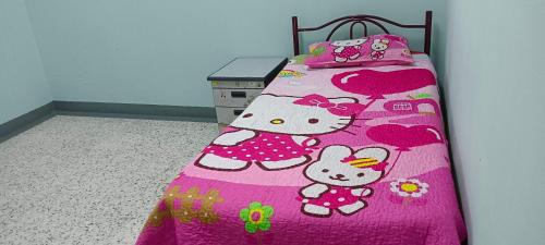 um quarto com uma cama com um cobertor rosa em Jauharee Homestay Muar Entire Home em Muar
