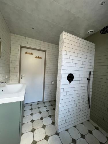a bathroom with a sink and a white door at Wellness Huisje 52 in Ewijk