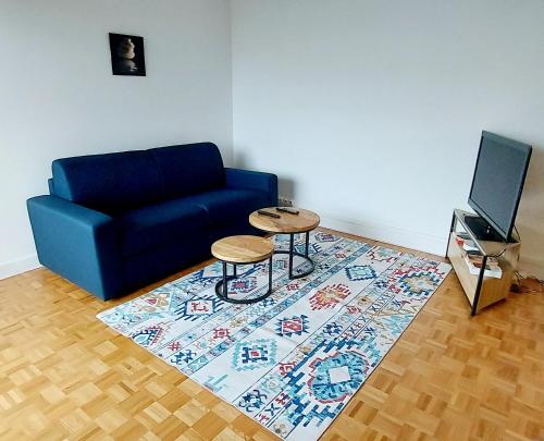 uma sala de estar com um sofá e duas mesas num tapete em Bel appartement à 9 minutes de Paris em Bois-Colombes