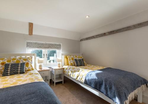 1 dormitorio con 2 camas y ventana en Honeysuckle Cottage - Bramfield, en Bramfield