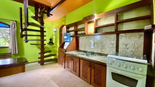 a kitchen with green walls and a white stove top oven at Casa de Campo - Condomínio Arco Íris in Atibaia