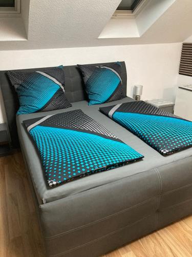 a couch with blue pillows on top of it at Home- Alt-Winzerla in Jena
