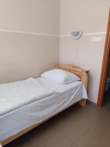a small bedroom with a bed and a lamp at Thermál Panzió Kiskunmajsa in Kiskunmajsa