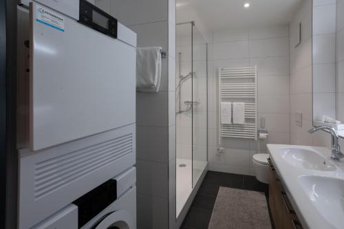 a white bathroom with a sink and a toilet at Wysses Rössli Swiss Quality Hotel in Schwyz