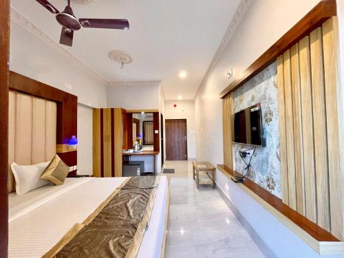 um quarto de hotel com uma cama e uma televisão de ecrã plano em Hotel A One Lagoon ! Puri Swimming-pool, near-sea-beach-and-temple fully-air-conditioned-hotel with-lift-and-parking-facility breakfast-included em Puri