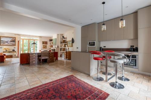 une cuisine avec une table et des chaises rouges dans une pièce dans l'établissement Veeve - Hint of the Exotic, à Boulogne-Billancourt