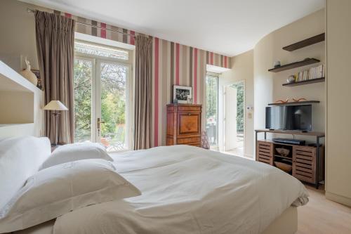 une chambre avec un grand lit blanc et une fenêtre dans l'établissement Veeve - Hint of the Exotic, à Boulogne-Billancourt