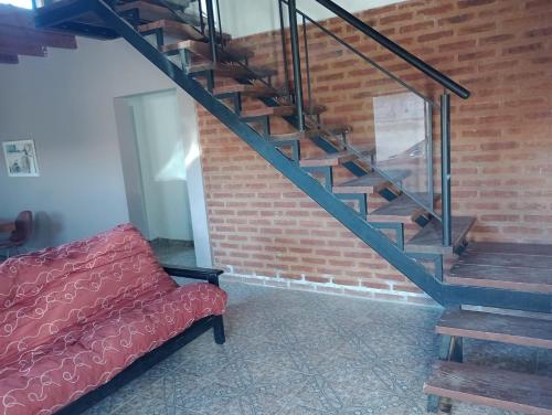 a red couch sitting next to a brick staircase at Casagrande Centenario in Centenario