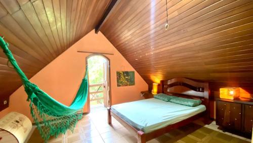 a bed in a room with a hammock in it at Casa de Campo - Condomínio Arco Íris in Atibaia