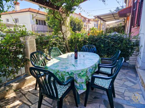 een tafel met vier stoelen en een fles wijn bij Holiday House Srečka in Izola