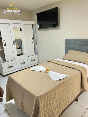 a bedroom with two beds and a dresser with a mirror at Hotel Aconchego Cearense in Fortaleza