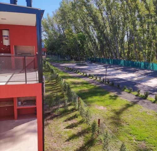 une clôture à côté d'une cour avec de l'herbe et des arbres dans l'établissement Altos de la Cañada, à Pilar