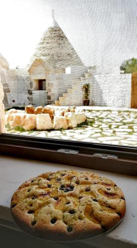 a pizza sitting in front of a display window at Masseria Dirupo in Noci