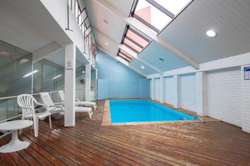 una piscina en una habitación con mesa y sillas en Hotel Nacional Inn Curitiba Torres, en Curitiba