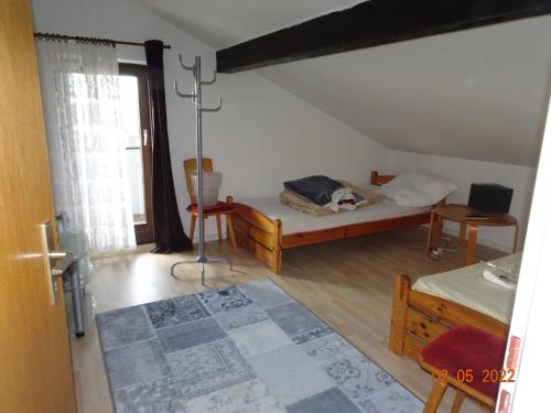 Habitación pequeña con cama y ventana en Pension Anderl, en Bodenmais