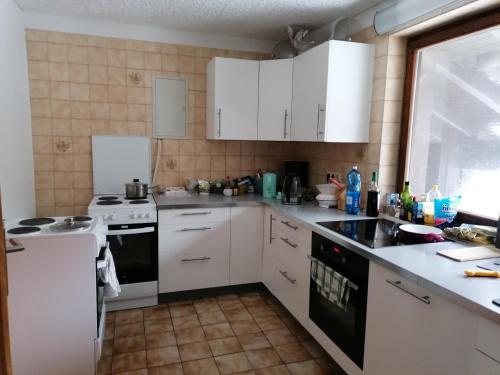 a kitchen with white cabinets and white appliances at Pension Anderl in Bodenmais