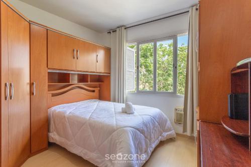 um quarto com uma cama e uma janela em Apto confortável Bem localizado em POA EBA0401 em Porto Alegre