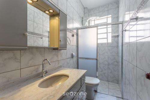 a bathroom with a sink and a toilet and a shower at Apto confortável Bem localizado em POA EBA0401 in Porto Alegre