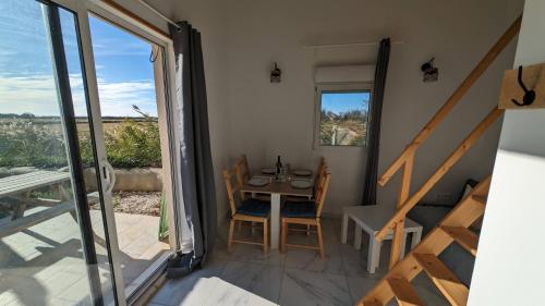 een kleine eetkamer met een tafel en een balkon bij Appartement au coeur des rizières in Salin-de-Giraud