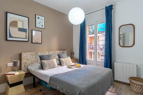 - une chambre avec un lit doté de rideaux bleus et d'une fenêtre dans l'établissement 4212 - AB Poble Sec, à Barcelone