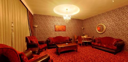 a living room with red furniture and a chandelier at Demosan Hotel in Karaman