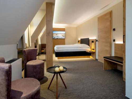 ein Hotelzimmer mit einem Bett und einigen Stühlen in der Unterkunft NASHI Rooms in Erfurt