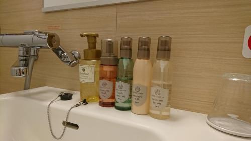 a group of bottles sitting on top of a sink at Queens Hotel Chitose in Chitose
