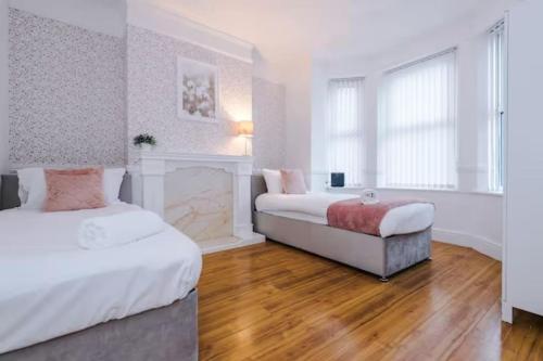 a bedroom with two beds and a fireplace at Spacious 4-Bed House Manchester in Manchester