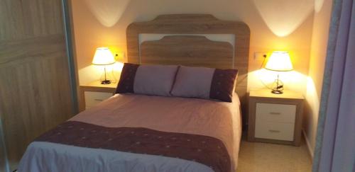 a bedroom with a bed with two lamps on it at Apartamento la Fragata Nerja in Nerja