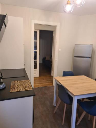 une cuisine et une salle à manger avec une table et des chaises bleues dans l'établissement Le Déodatien, à Saint-Dié-des-Vosges