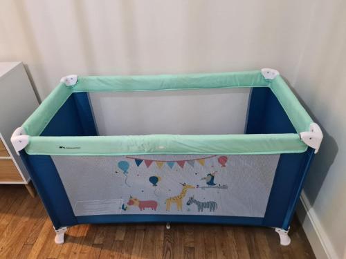 a baby crib with a blue and green top at Le Déodatien in Saint Die