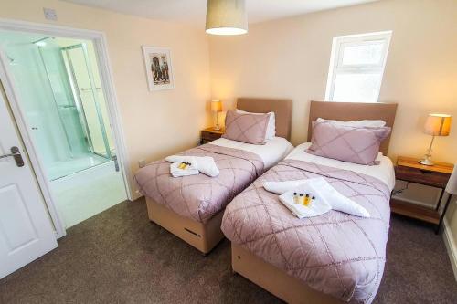 2 Betten in einem kleinen Zimmer mit rosa Bettwäsche in der Unterkunft Charming 2-Bed Apartment in Stroud in Stroud