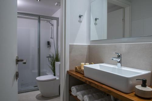 a bathroom with a white sink and a toilet at Athinais Grey in Heraklio