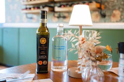 a bottle of wine sitting on a table with a lamp at EcoHotel Ristorante Milano in Borgo a Mozzano