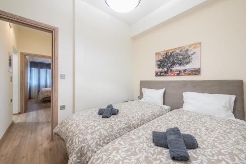 a bedroom with two beds with towels on them at Panathenaic Stadium By Greece Apartments in Athens