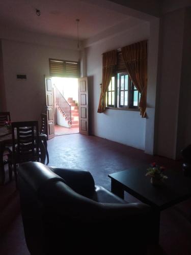 a living room with a couch and a table at New Dulmi Guest House. in Denipitiya