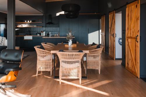 a dining room with a table and wicker chairs at Klein-Hangklip in Rooiels