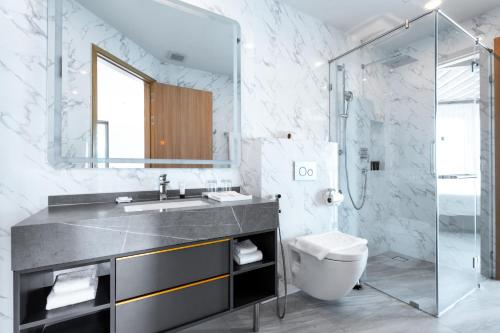 La salle de bains est pourvue d'un lavabo, de toilettes et d'un miroir. dans l'établissement Sole Mio Boutique Hotel and Wellness - Adults Only, à Bang Tao Beach